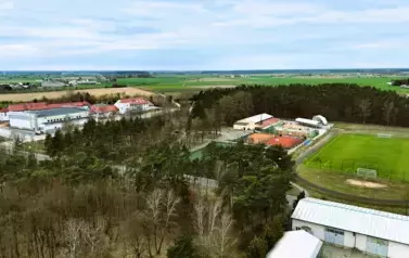 Panorama Ryczywołu, widoczne boiska sportowe, szkoła oraz hala sportowa