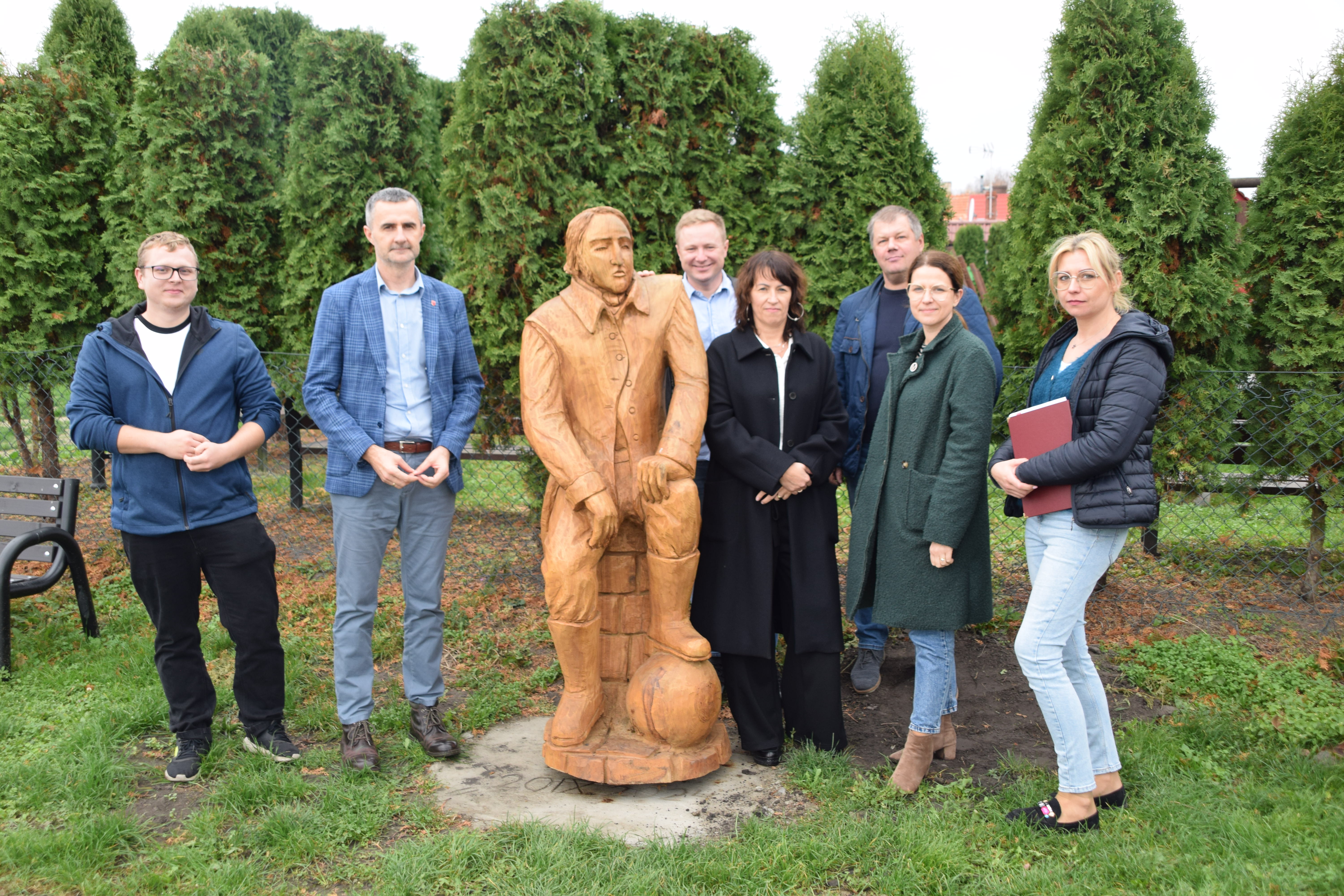 zdjęcie przedstawia osoby obecne na&nbsp;odbiorze terenu rekreacyjnego w&nbsp;Dąbr&oacute;wce Ludomskiej przy rzeźbie Karola Marcinkowskiego 