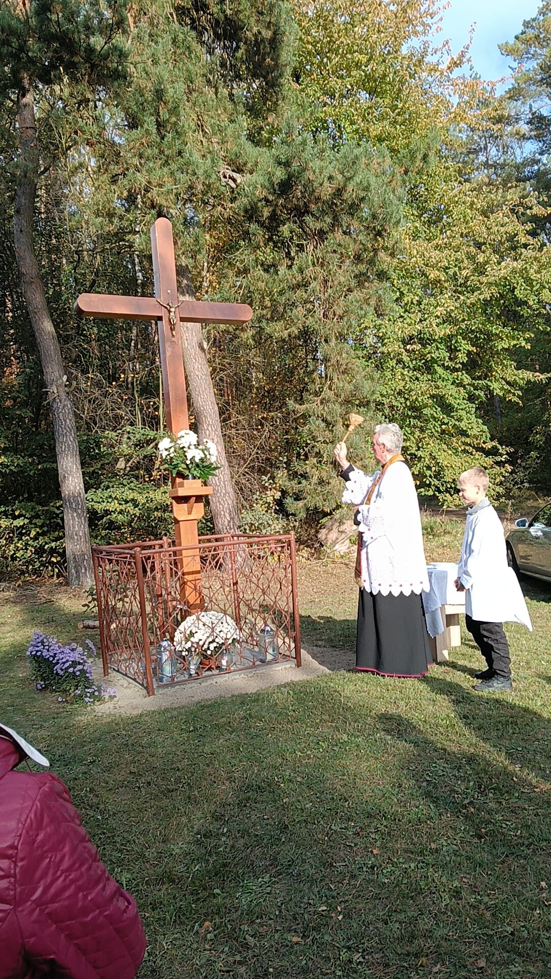 zdjęcie ukazuje księdza proboszcza, kt&oacute;ry święci nowy krzyż w&nbsp;miejscowości Piotrowo