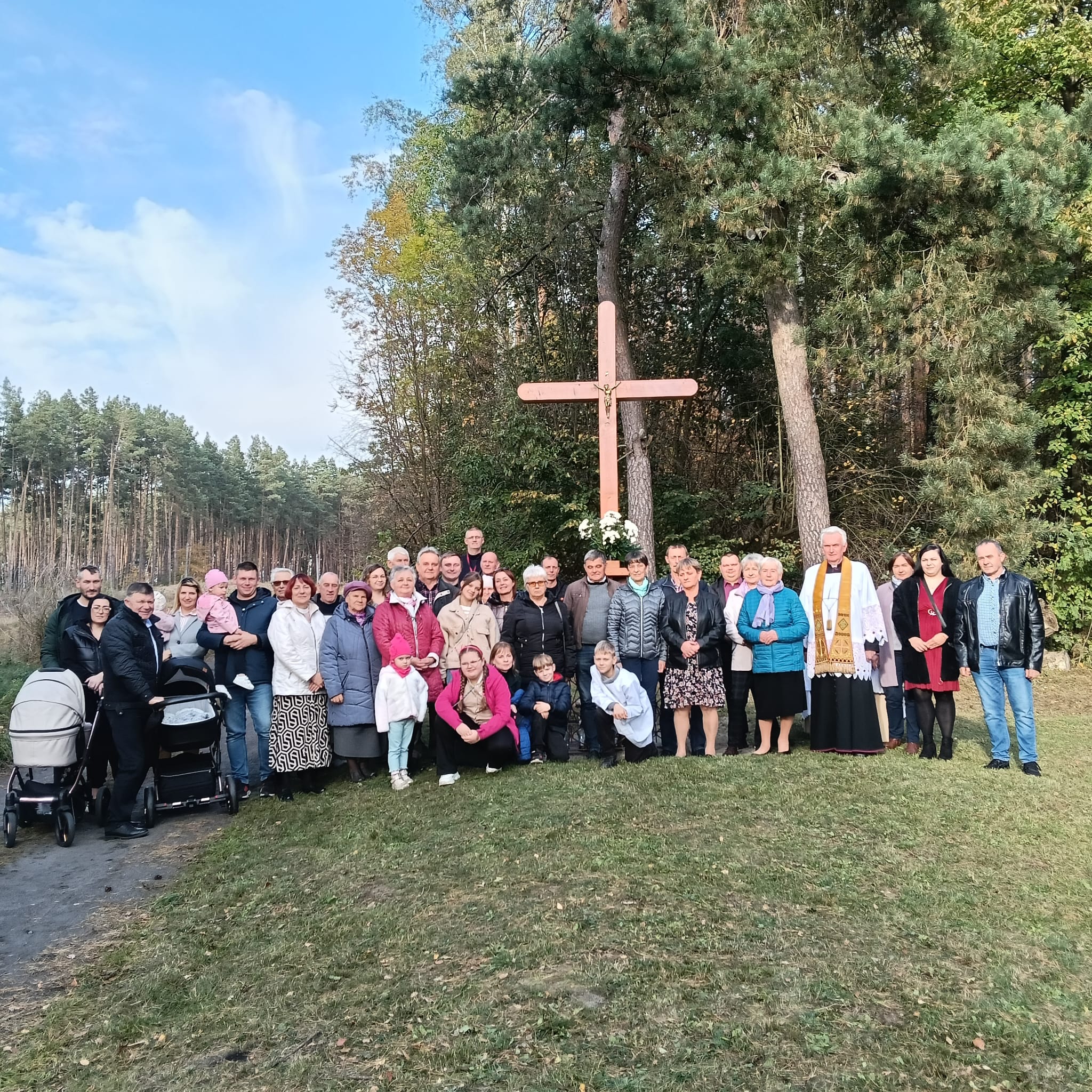 zdjęcie przedstawia grupę mieszkańc&oacute;w sołectwa Piotrowo, kt&oacute;rzy zebrali się przed nowym krzyżem z&nbsp;okazji jego poświęcenia 