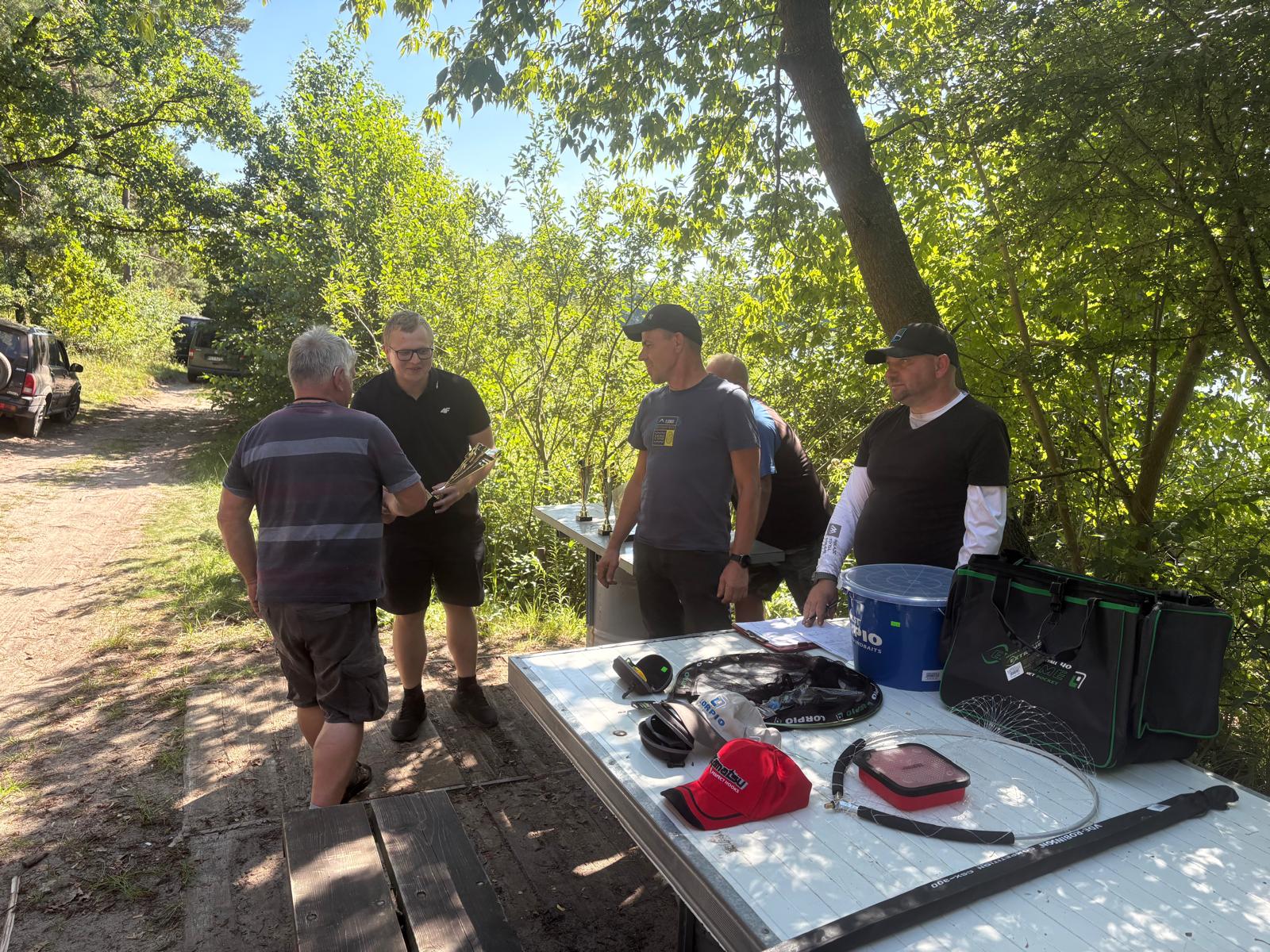 Zdjęcie przedstawia wręczanie pucharu przez Przewodniczącego Rady Gminy Ryczyw&oacute;ł Szymona Chmielewskiego uczestnikowy zawod&oacute;w Wędkarskich o&nbsp;Puchar W&oacute;jta Gminy Ryczyw&oacute;ł.
