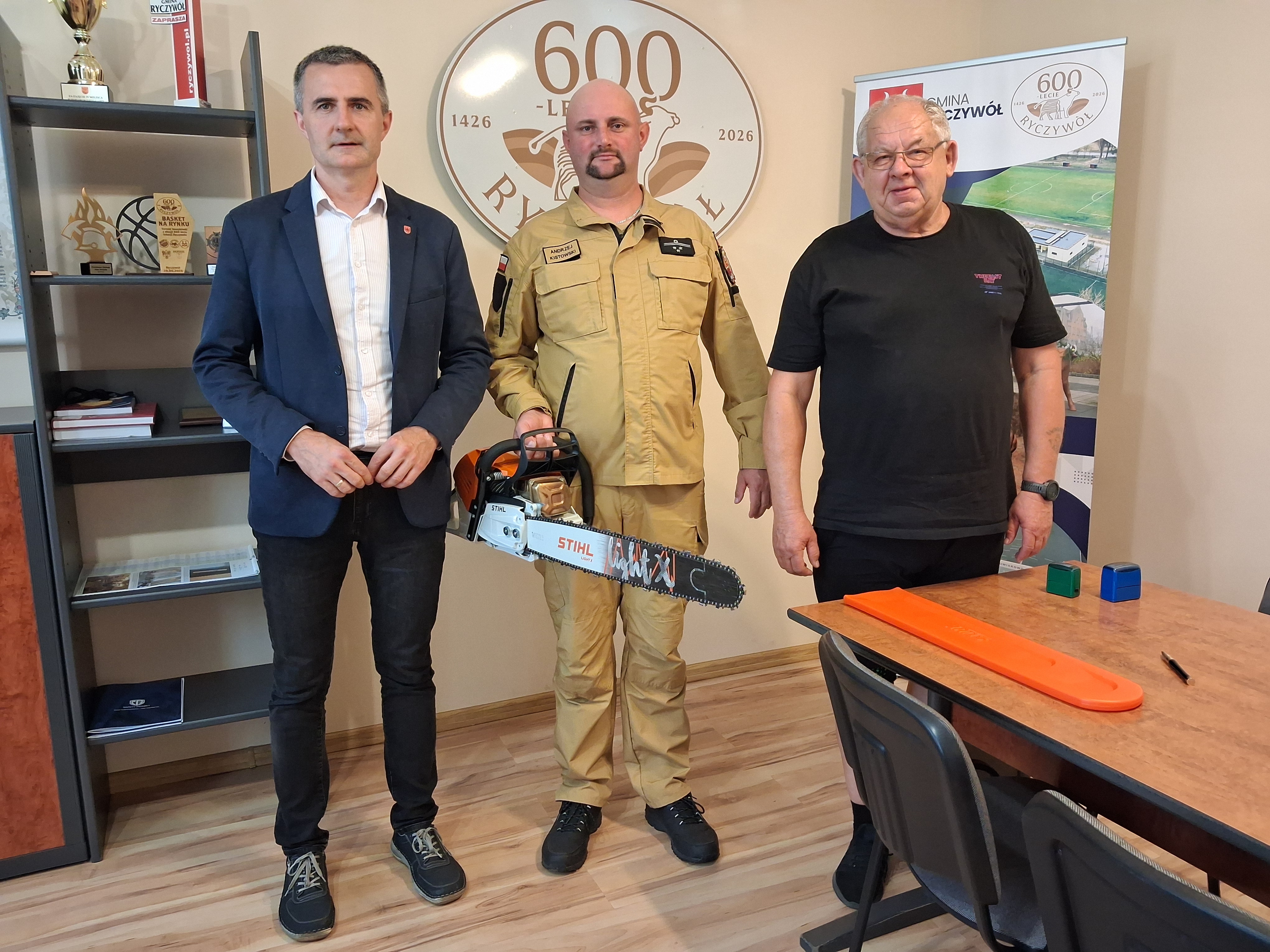 Zdjęcie przedstawia W&oacute;jta Gminy Ryczyw&oacute;ł z&nbsp;Prezesem OSP w&nbsp;Ryczywole oraz&nbsp;Komendantem 