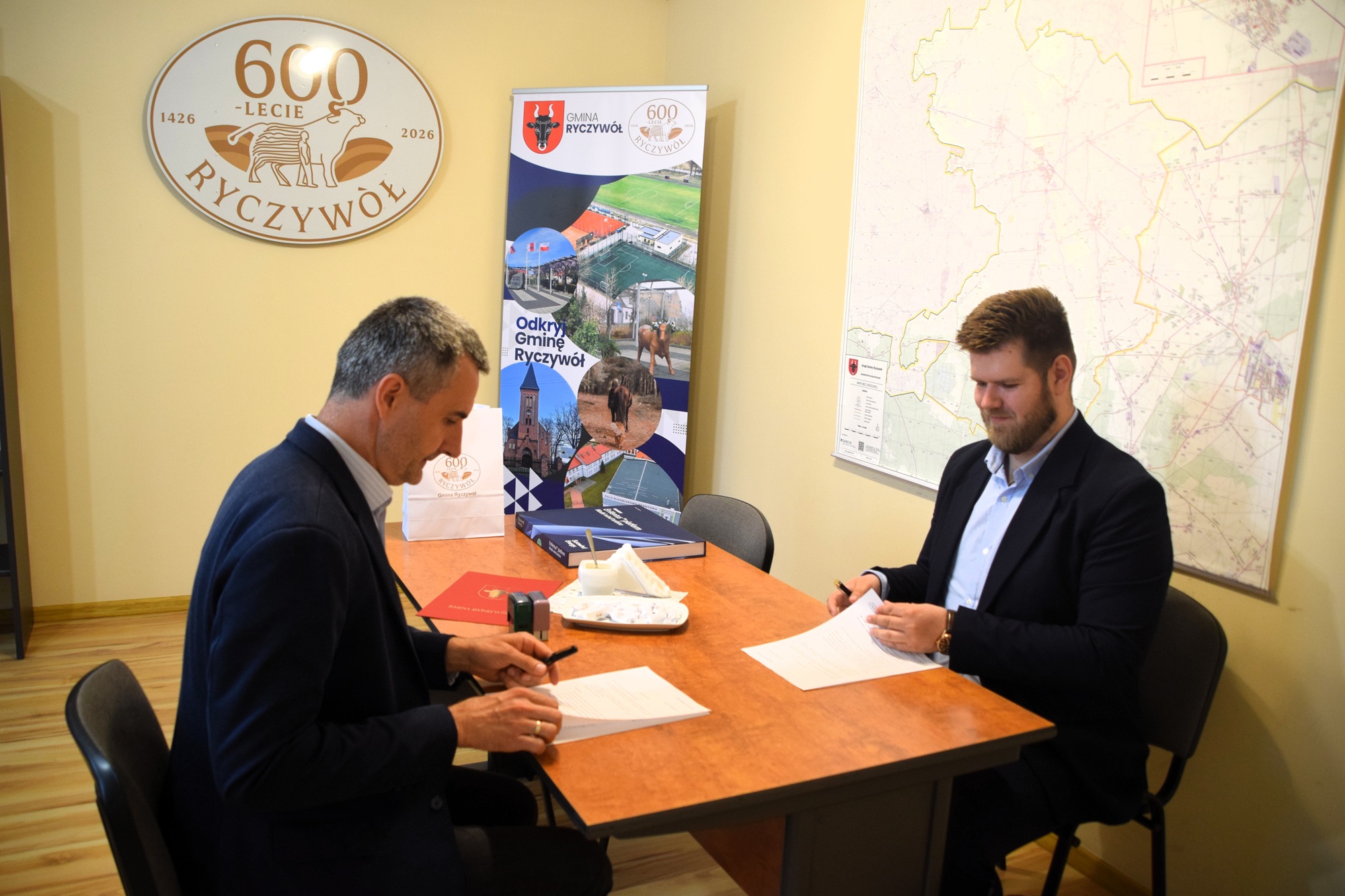 Zdjęcie przedstawia W&oacute;jta Gminy Ryczyw&oacute;ł oraz&nbsp;przedstawiciela firmy Eurowind Energy Sp. z&nbsp;o.o. podczas podpisywania porozumienia o&nbsp;wsp&oacute;łpracy. 