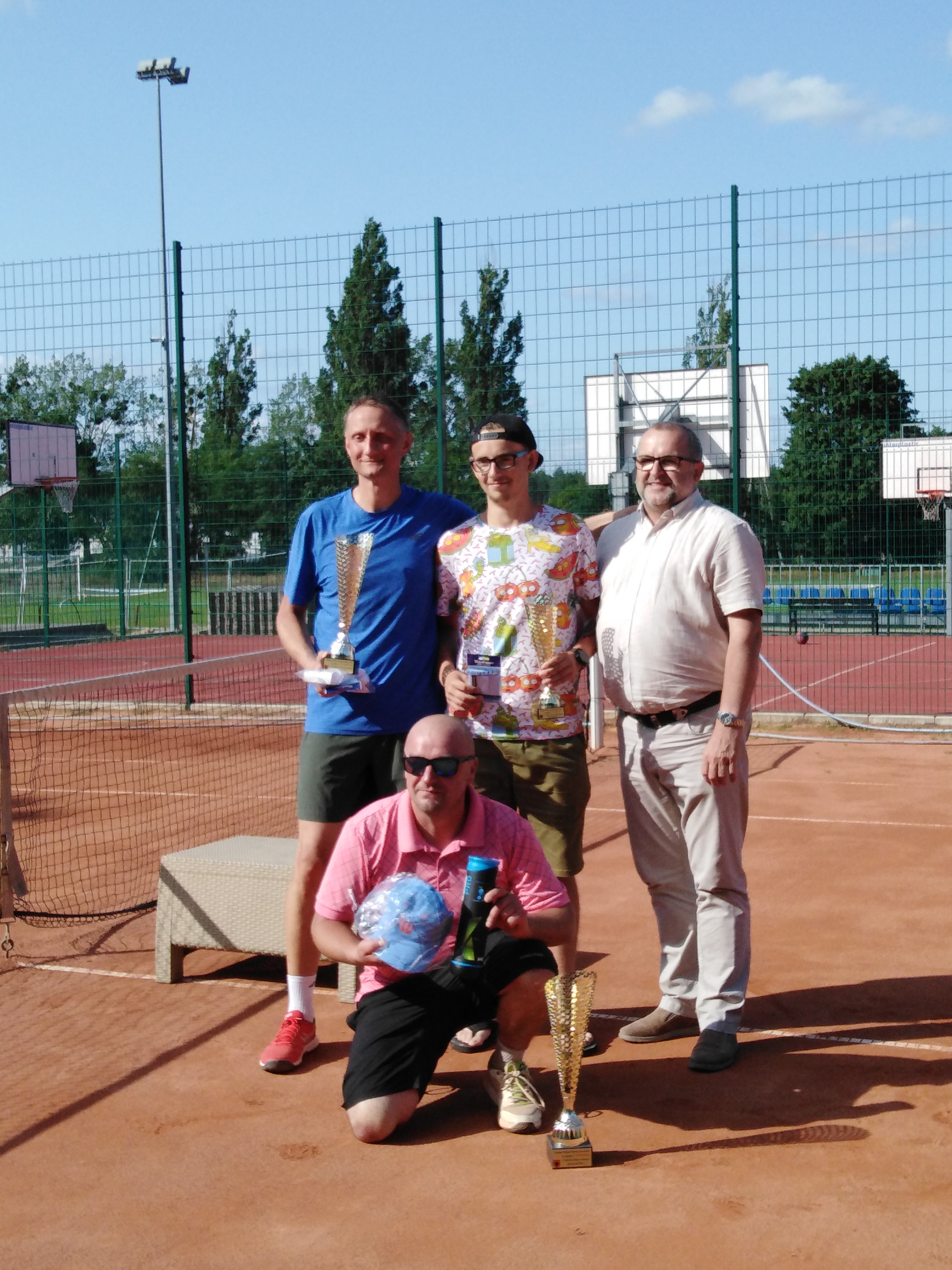 zdjęcie przedstawia kort tenisowy, na którym stoją: Wójt Gminy Ryczywół, p. Dariusz Łata, p. Grzegorz Berndt oraz p. Adam Grabowski z wręczonymi pucharami.